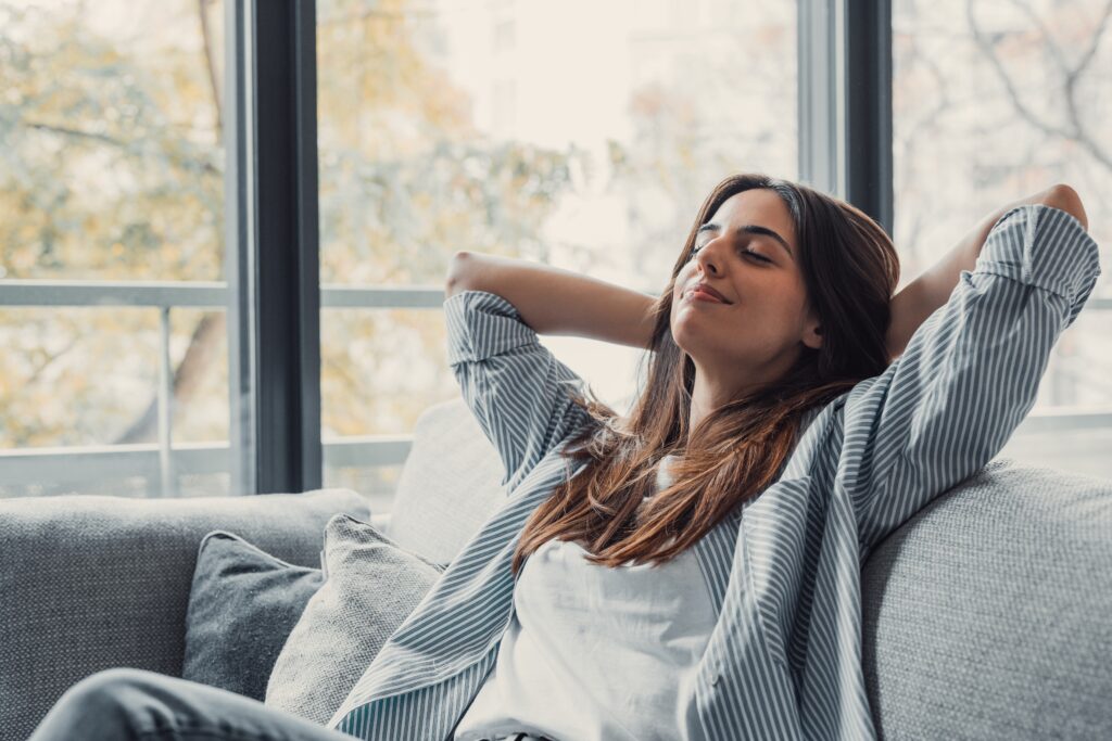 A woman relaxes peacefully, reflecting calm and staying grounded.