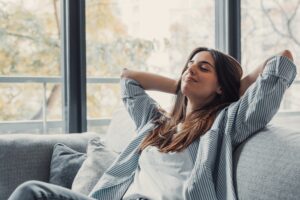 A woman relaxes peacefully, reflecting calm and staying grounded.